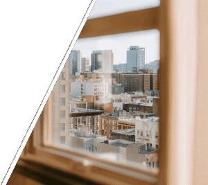 A minimalist office window looking out onto urban buildings, capturing the experience of high-functioning adults silently coping with chronic conditions. Ideal representation of holistic therapy for chronic illness, mind-body therapy for chronic pain, and compassionate therapy for invisible illness. Reflects the need for psychological support for chronic illness, personalized therapy for long-term illness, and counseling for medically unexplained symptoms in high-stress urban environments.
