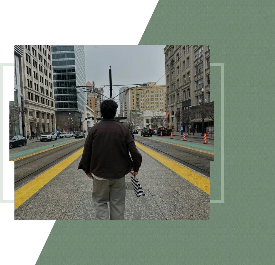 A person walks on a city street with a striped bag
