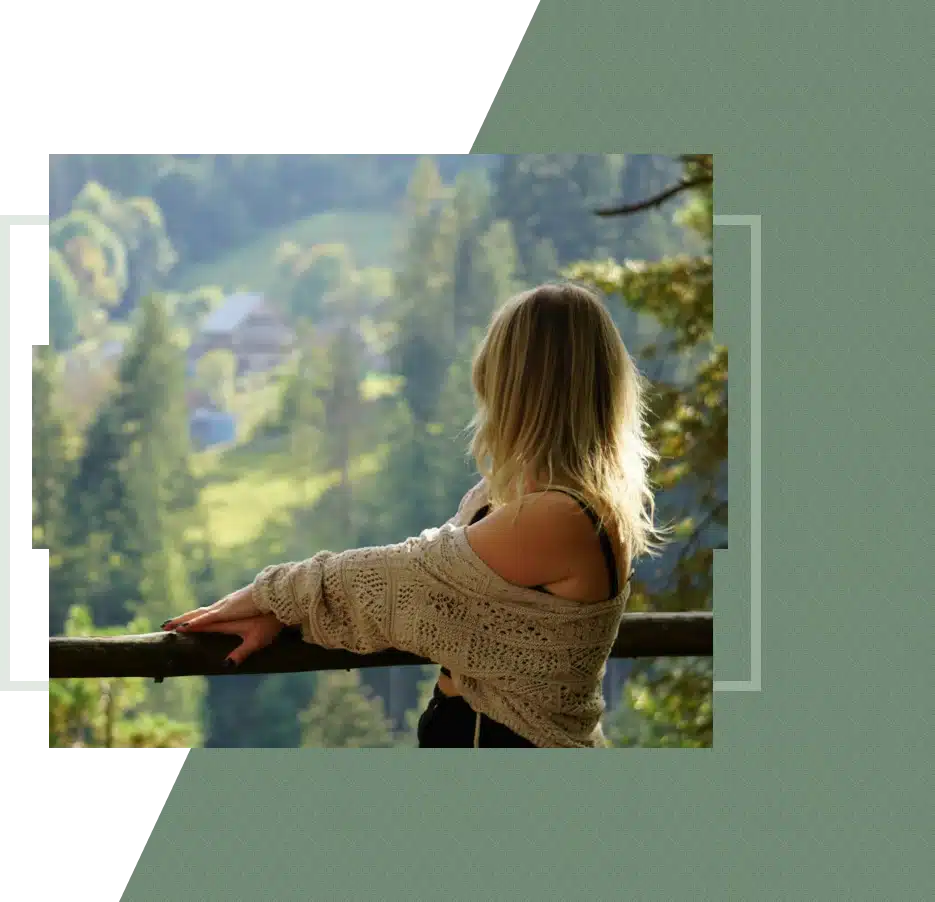A woman looks out at a mountain valley
