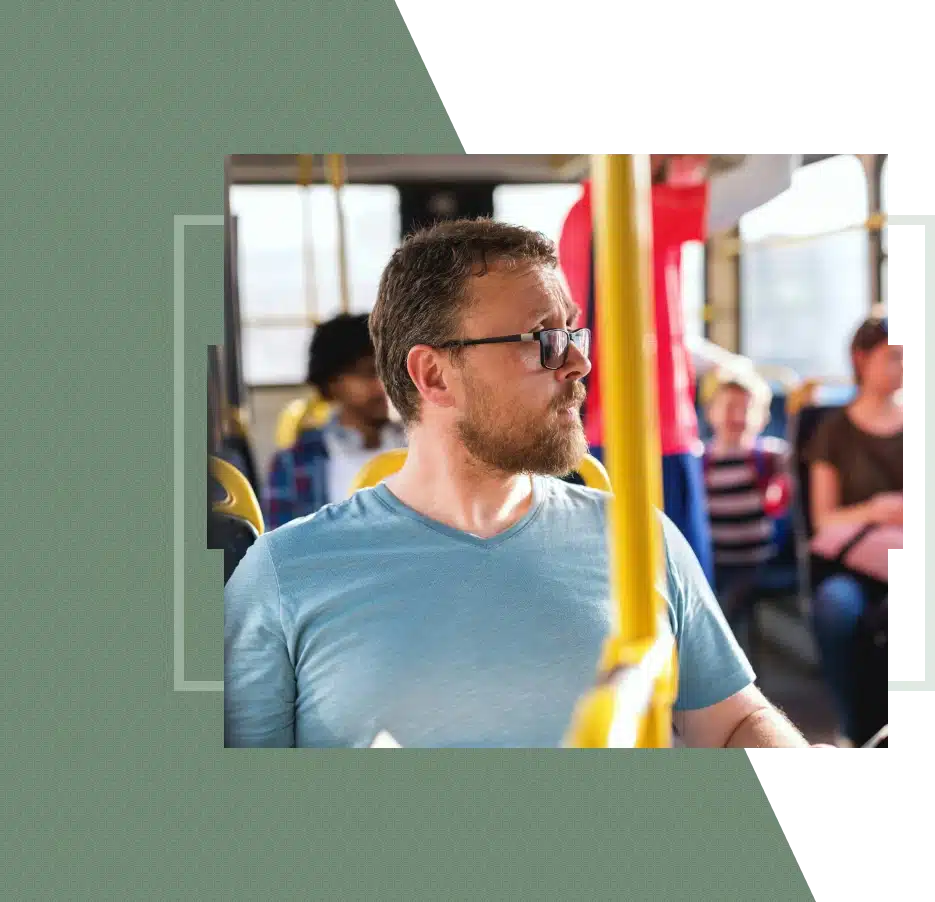 A man on a bus looks out the window.