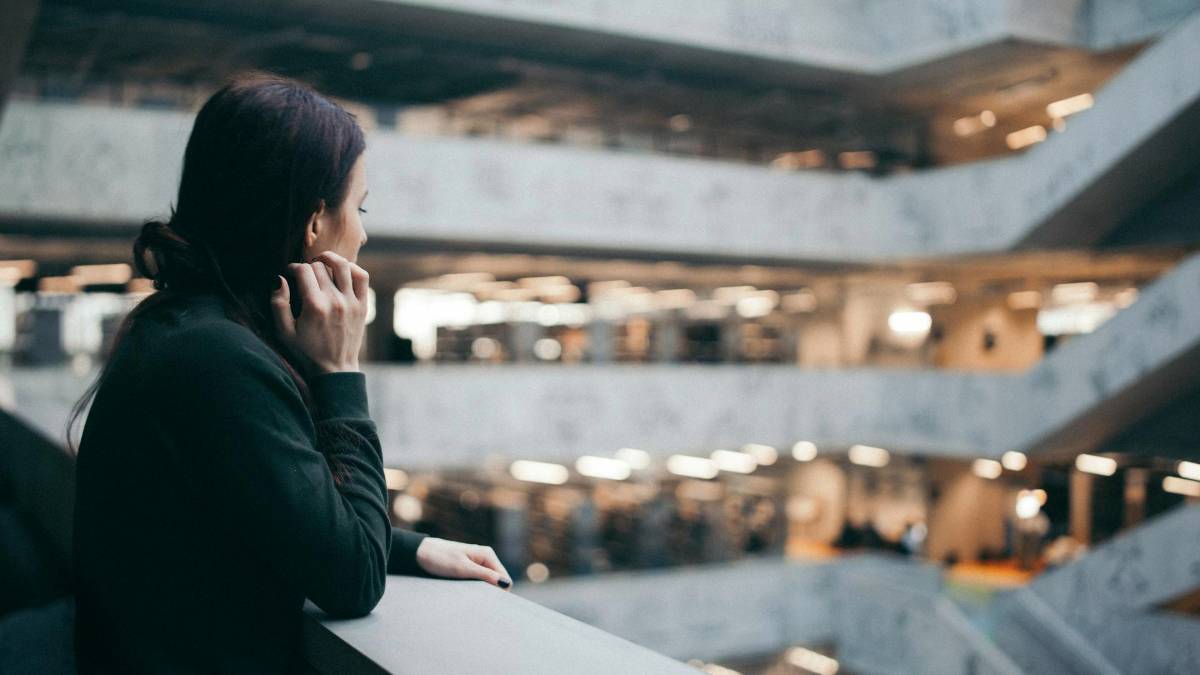 Woman reflecting in a modern building, symbolizing ADHD assessment and the process of seeking clarity.