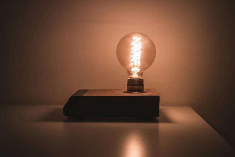 Glowing light bulb on wooden base, representing inspiration and creative ideas