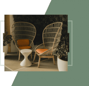 Two wicker chairs against a green wall.
