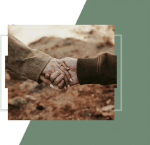 Close-up of two people holding hands, one wearing an engagement ring