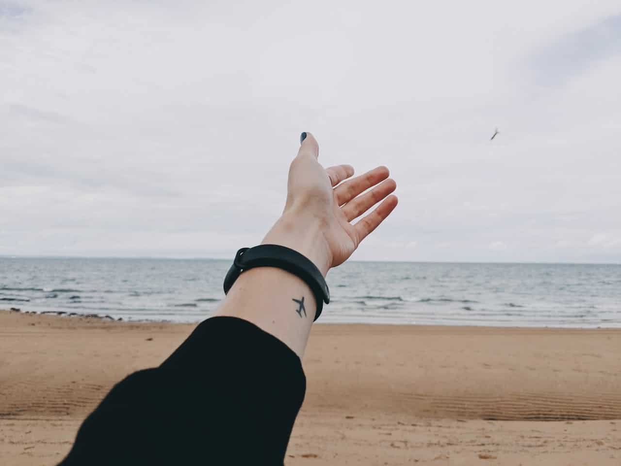 A hand reaching toward the ocean, representing hope, emotional clarity, and progress in depression therapy.