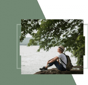 Woman sitting peacefully overlooking water and landscape with scenic mountain view