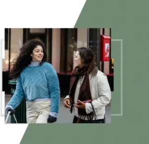 Two girls crossing a city street while talking and smiling, a casual moment of friendship and ease