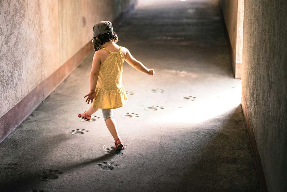 Girl stepping on paw prints.