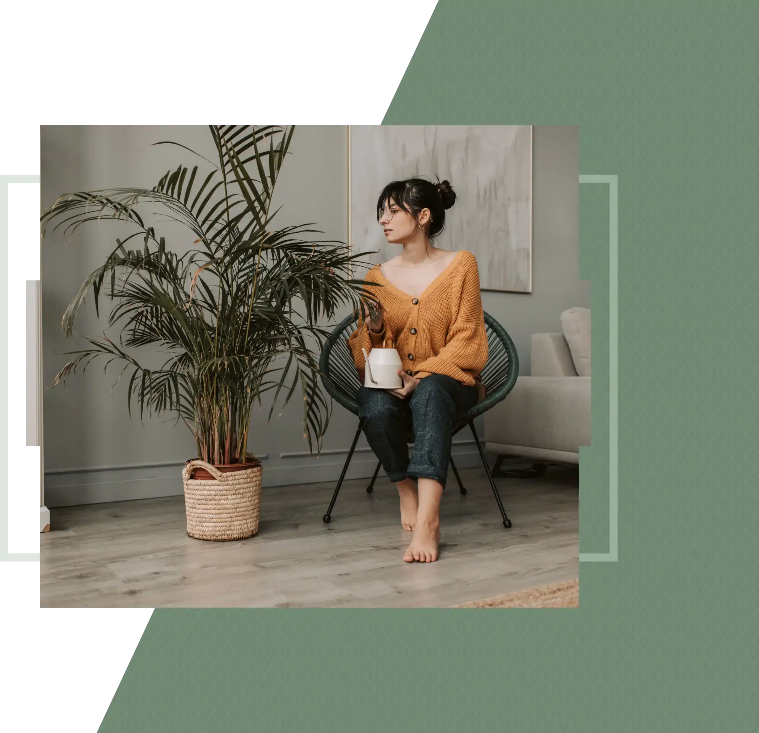 A woman sitting in a chair holding a small watering can next to a large indoor plant.